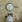 Room interior with floral wallpaper, round mirror, desk, chair, and digital clock.
